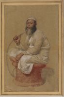 Man seated on a drum smoking a hookah