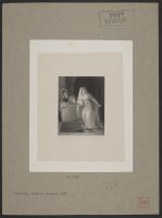 A man and woman sneaking down a dark passage, the man carrying a large, flat object